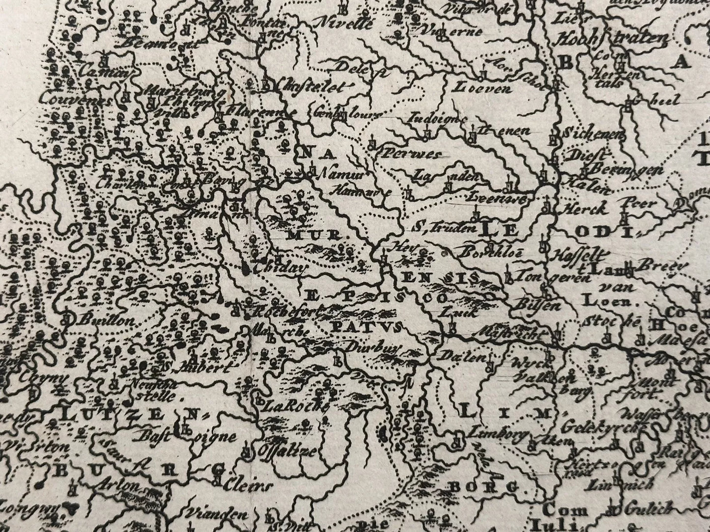 The product is an original antique map of modern Belgium or Lower Germany, dated 1697. It is a physical map printed using a copper plate technique by cartographer Philippi Cluveri. The map features a decorative antique cartouche and is from the 19th century.

Hodiernae Belgicae sive Germaniae Inferioris

Philippi Cluveri's "Introductionis in universam geographiam.. 1697

approx. 11.25 x 9 inches

copperplate engraving with hand coloring

Excellent condition: vertical folds as issued, penciled date at bottom
